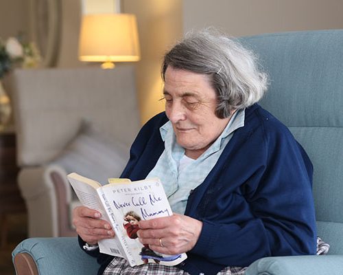 A resident relaxes with a good book in one of the communal areas at Elmhurst Care Home, Shropshire