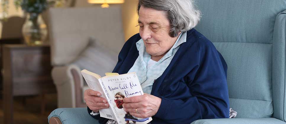 Shropshire-care-home-Elmhurst-resident-01 A resident relaxes with a good book in one of the communal areas at Elmhurst Care Home, Shropshire